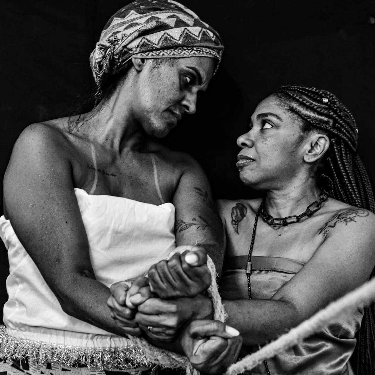 Duas mulheres se olham e unem as mãos em uma cena sobre apoio e resistência