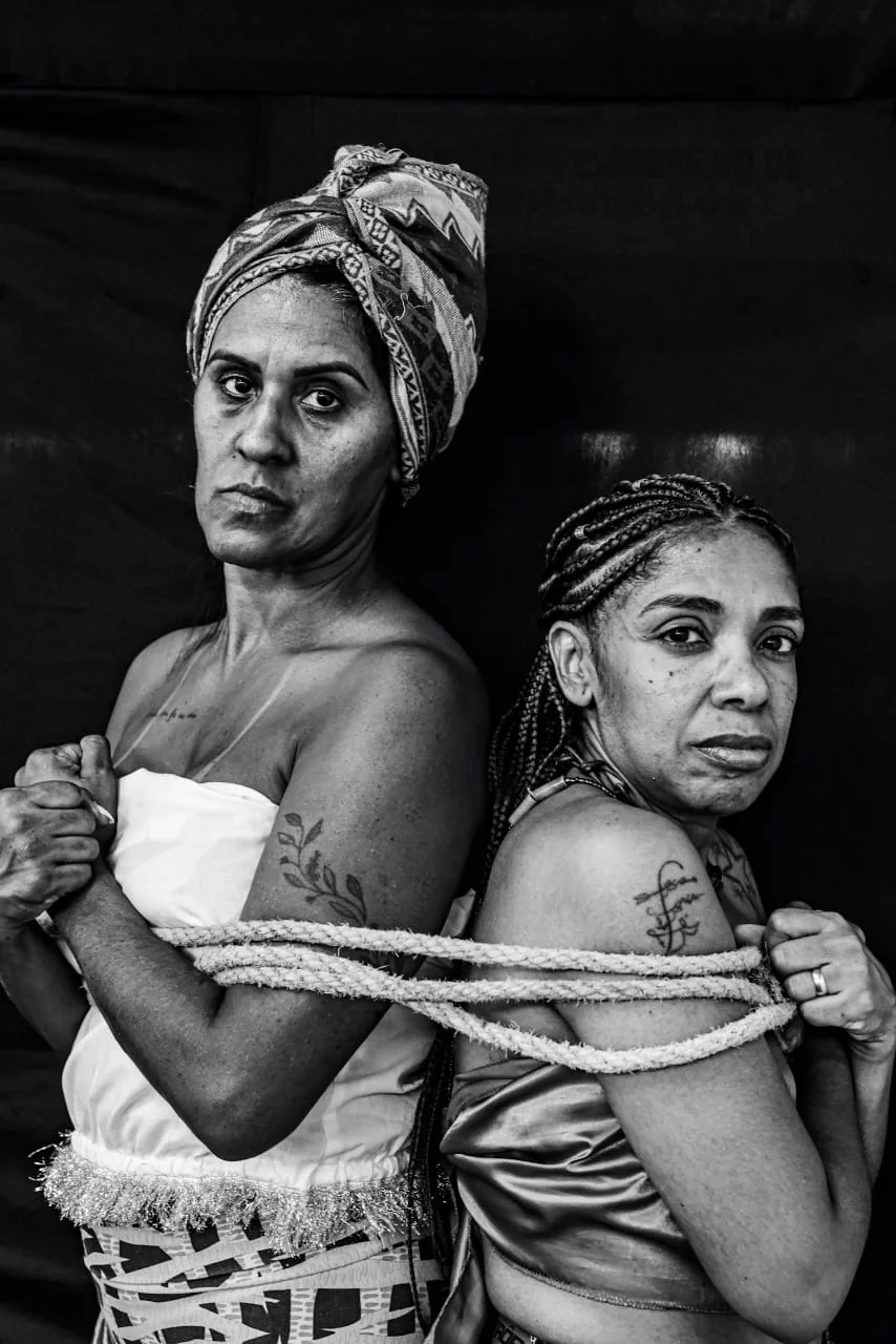 Duas mulheres estão unidas por uma corda em retrato simbólico